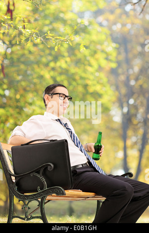 Homme d'affaires détendue en faisant une pause dans le parc assis sur banc en bois Banque D'Images