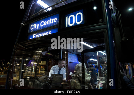 Les gens à bord du bus qui fait le trajet aéroport - centre-ville d'Édimbourg. Banque D'Images