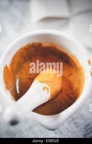 Turmeric powder mixed with honey in mortar for turmeric tea Banque D'Images