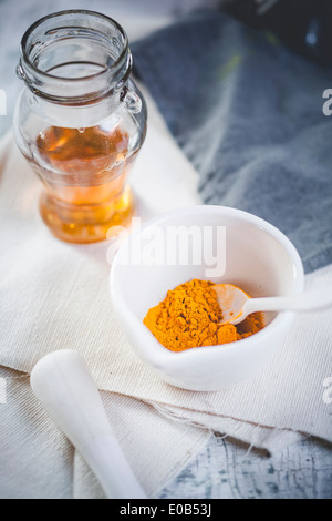 Turmeric in mortar and glas of honey for preparation turmeric tea Banque D'Images