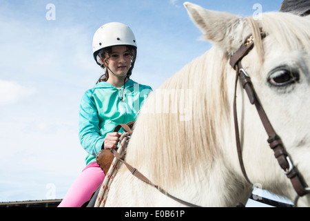 Girl siège au cheval blanc le port de casque en avril 2014. Randonnées à cheval, Rotorua. Banque D'Images