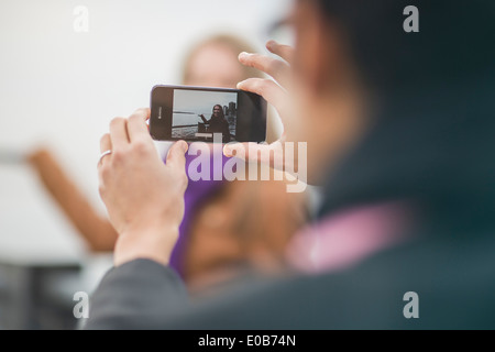 Close up of young man photographing copine on camera phone