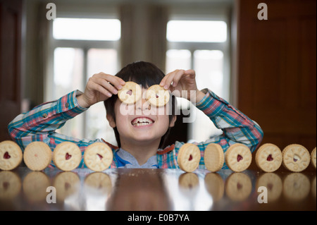 Garçon jouant avec des biscuits Banque D'Images