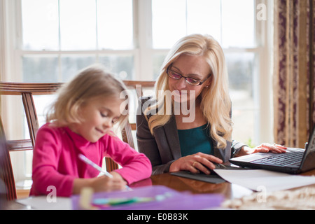 Mère et fille, faire des travaux et devoirs dans la salle à manger Banque D'Images