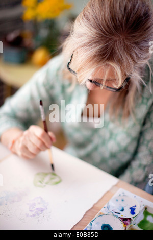 Close up of young female artist aquarelle en studio Banque D'Images
