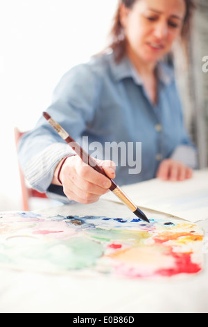 Femme mature en aquarelle peinture artiste studio Banque D'Images