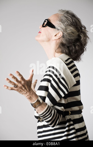 Portrait of senior woman, bras ouverts, side view Banque D'Images