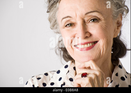 Portrait of senior woman, main sur le menton, smiling Banque D'Images