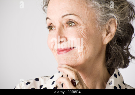 Portrait of senior woman, main sur le menton, smiling Banque D'Images