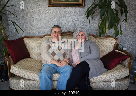 Portrait of mature couple sitting on sofa ornementé Banque D'Images