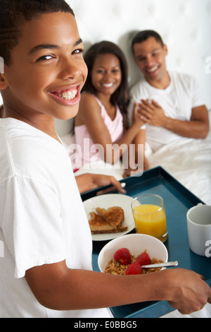 Fils de parents apportant le petit déjeuner au lit Banque D'Images