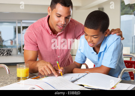 Père Fils aidant à faire leurs devoirs dans la cuisine Banque D'Images