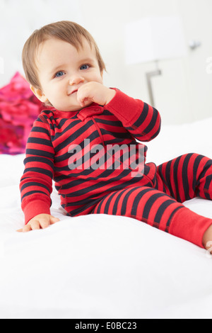 Toddler Sitting on Bed Wearing pajamas Banque D'Images