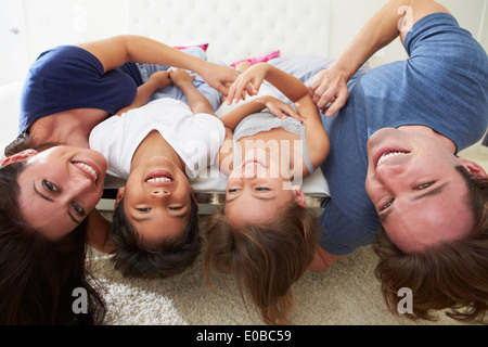 Famille couché à l'envers sur le lit dans un ensemble Pyjama Banque D'Images