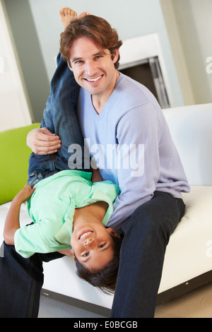 Père et Fils s'amusant sur canapé ensemble Banque D'Images