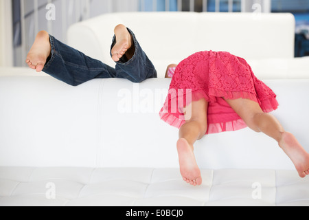 Vue arrière de deux enfants jouant sur canapé Banque D'Images