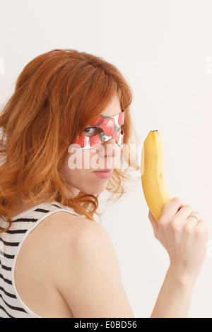 Superhero girl wearing mask avec des fraises Banque D'Images