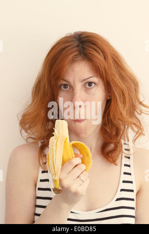 Jeune femme manger une banane Banque D'Images