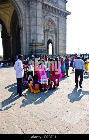 Porte de l'Inde,Appollo Bunder,Square, les touristes, les enfants de l'école en saris colorés,promenade,Ferry terminal,Bombay Mumbai, Inde, Banque D'Images