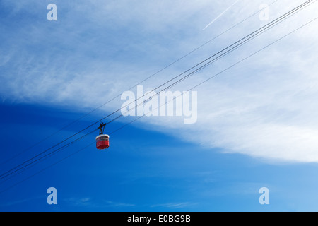 Cabine téléphérique rouge dans le ciel avec les nuages. Banque D'Images