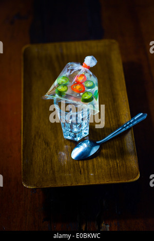 Ingrédients vinaigre poivre tranches petit lié [bande de caoutchouc] jeter mis [en haut] petit cristal tumbler à côté de l'acier inoxydable thé cuillère Banque D'Images