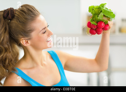 Portrait of happy young woman holding radishes Banque D'Images