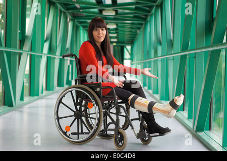 Jeune femme à la jambe de gypse est assis dans un fauteuil roulant, Junge Frau mit einem Rollstuhl Gipsbein sitzt Banque D'Images