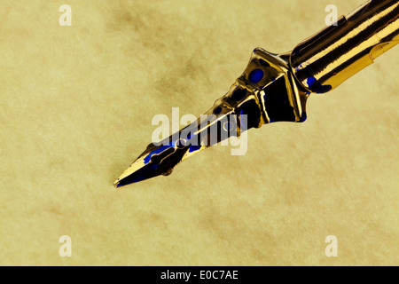 Une écriture bleue vers le bas avec un pot d'encre sur fond blanc, Eine blaue Schreibfeder mit einem Tintenfass auf weissem Hintergrund Banque D'Images