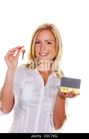 Une jeune femme avec un modèle chambre et télévision., eine junge Frau mit einem Modell und Wohnungsschluessel Haus. Banque D'Images