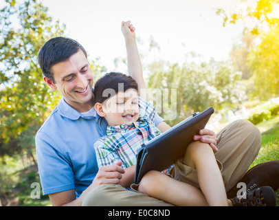 Handsome Mixed Race Woman sur un ordinateur Tablet à l'extérieur. Banque D'Images