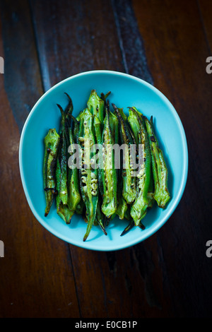 [Sauté de Okra] fendues cleave [le long de la longueur] frites avec de l'huile [lay mis sur] la [couleur cyan pâle food plate] Banque D'Images