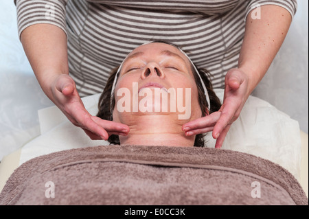 Une femme au début des années 60 ayant un soin du visage et maquillage soin de beauté par un thérapeute de beauté Banque D'Images