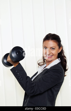 Garçon, entreprise avec succès dans le bureau. Si un titulaire d'haltère, Junge, erfolgreiche Unternehmerin Buero gi. Haelt eine Hantel Banque D'Images