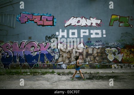 Odessa, Ukraine. 9 mai, 2014. Ukraine - Odessa - vie quotidienne - une jeune femme marche devant un mur de graffiti, dans une rue abandonnée, Odessa, Ukraine, le Jeudi, Mai 8, 2014. (Zacharie Scheurer) © Zacharie Scheurer/NurPhoto ZUMAPRESS.com/Alamy/Live News Banque D'Images