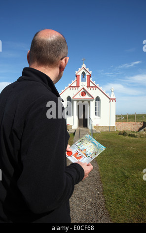 Homme avec une notice a l'extérieur de la chapelle à Orkney Banque D'Images