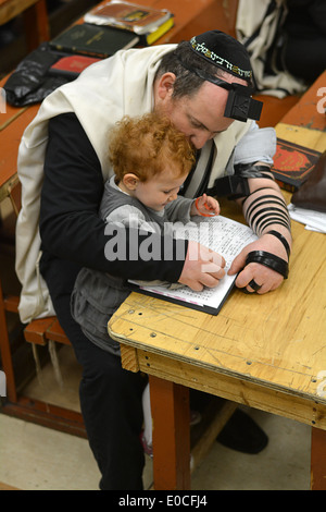 Père juif religieux et de l'enfant lecture à la synagogue. Banque D'Images