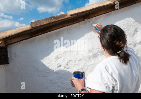 Femme l'étanchéité sur la terrasse du toit bois exposés d'une villa de vacances. Banque D'Images