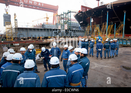 Les travailleurs des chantiers navals de faire des exercices du matin avant de passer à la production modulaire, plus grand chantier naval dans le monde Hyundai Heavy Industries Banque D'Images