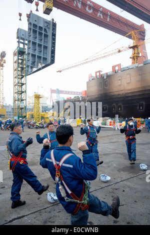 Les travailleurs des chantiers navals de faire des exercices du matin, avant de passer à la production modulaire le plus grand chantier naval dans le monde Hyundai Heavy Ind Banque D'Images