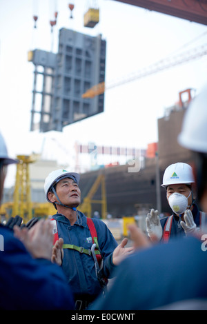 Les travailleurs des chantiers navals de faire des exercices du matin, avant de passer à la production modulaire le plus grand chantier naval dans le monde Hyundai Heavy Ind Banque D'Images