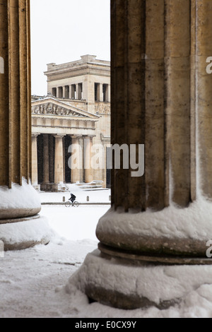 Koenigsplatz couverte de neige, cycliste en face de Propylaen, vue de l'Antikensammlung, Munich, Berlin, Allemagne Banque D'Images