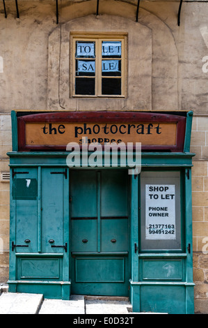 La façade verte avec volets d'une boutique de photographies fermée avec afficher des fenêtres sur différents niveaux pour correspondre aux pas à l'extérieur Banque D'Images