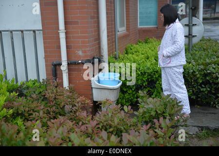 Dalian, province de Jiangsu. 10 mai, 2014. Un résident local reçoit l'eau d'un robinet à une zone résidentielle de Dalian, province de Jiangsu Chine orientale, le 10 mai 2014. L'approvisionnement en eau de Jingjiang reprend le vendredi après avoir été suspendu pendant 7 heures, en raison de la qualité de l'eau anormale trouvé dans la rivière Yangtze, source d'eau. Cependant, certaines zones d'habitation se heurtent toujours au problème de pénurie d'eau. © Shen Peng/Xinhua/Alamy Live News Banque D'Images