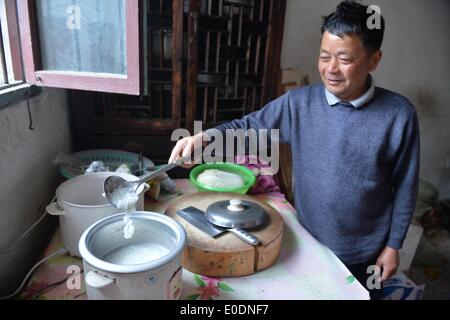 Dalian, province de Jiangsu. 10 mai, 2014. Un résident local rend le petit-déjeuner avec l'alimentation en eau, ce qui n'a pas reprendre jusqu'à 1:00 dans Yuejiang Canton de Dalian, province de Jiangsu Chine orientale, le 10 mai 2014. L'approvisionnement en eau de Jingjiang reprend le vendredi après avoir été suspendu pendant 7 heures, en raison de la qualité de l'eau anormale trouvé dans la rivière Yangtze, source d'eau. Cependant, certaines zones d'habitation se heurtent toujours au problème de pénurie d'eau. © Shen Peng/Xinhua/Alamy Live News Banque D'Images