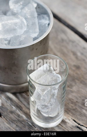 Verre avec des glaçons et seau à glace rempli de glaçons Banque D'Images