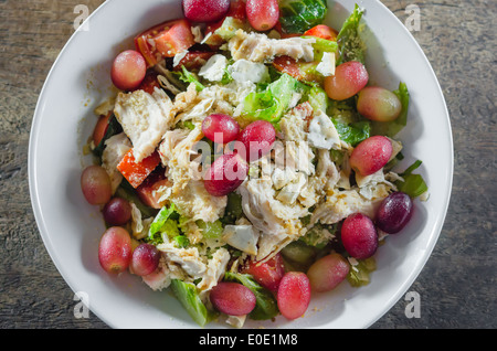 Mélanger avec la salade de poulet et les raisins sur le plat blanc Banque D'Images