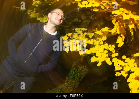 Casual dressed man with hands in pocket bénéficie de la couleurs de l'automne park Banque D'Images