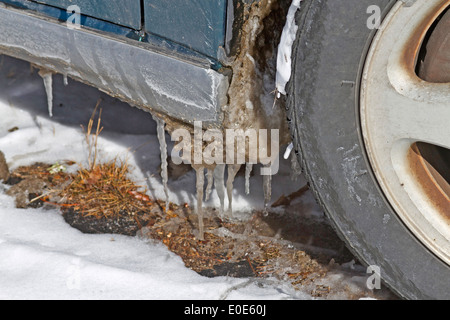 Une voiture avec des glaçons pendant de il commence un dégel en hiver Banque D'Images