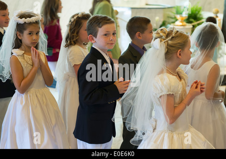 Garçons et filles catholiques recevant le Sacrement de la première communion. Banque D'Images