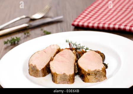 Trois tranches de filets de porc grillés sur une plaque blanche Banque D'Images